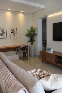 a living room with a couch and a tv at Design e Amor no Centro in Palmas