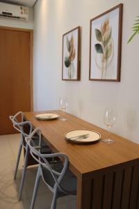 a wooden table with two chairs and two wine glasses at Design e Amor no Centro in Palmas