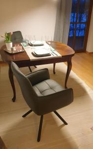 a wooden table with a chair and wine glasses at Frisch renoviertes BergSeeNest in Bad Bayersoien +22 photos