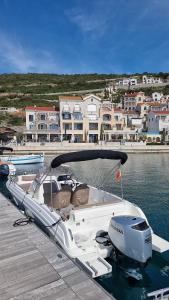 a white boat parked at a dock in the water at Grünner Apartments in Dobrota