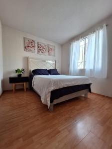 a bedroom with a large bed and a window at Hermoso departamento cómodo in San Lorenzo Tetlixtac +51 photos