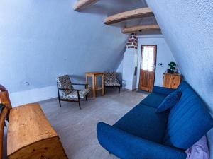a living room with a blue couch and a table at Chata Geruša in Čebovce