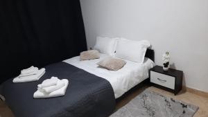 a bedroom with a bed with white towels on it at White Apartment in Bîrlad