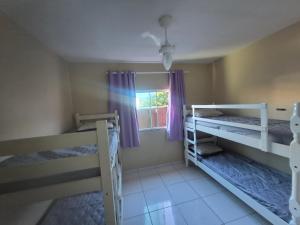 a bedroom with two bunk beds and a window at Casa Recanto de Unamar in Cabo Frio +42 photos