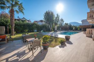 a patio with a pool and a table with plants at Kalender Pansiyon Fethiye in Fethiye