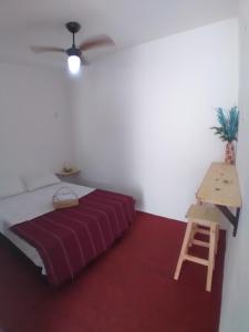 a bedroom with a bed and a wooden table at Pousada Nosso Sonho in Natal