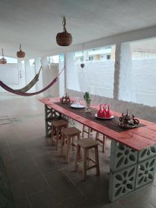 a large wooden table with stools in a room at Pousada Nosso Sonho in Natal