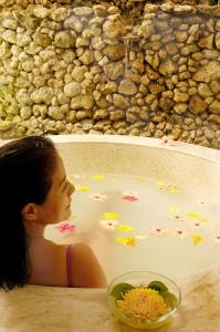 a woman sitting in a bath tub filled with flowers at Punta Bulata White Beach Resort & Spa in Sipalay