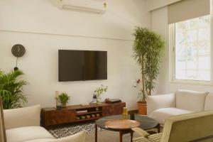 a living room with a flat screen tv on the wall at A Modern 2BHK Private Villa in Vagator - Valenades in Vagator +14 photos