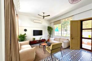 a living room with a couch and a tv at A Modern 2BHK Private Villa in Vagator - Valenades in Vagator