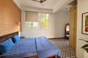 a bedroom with a blue bed and a window at A Modern 2BHK Private Villa in Vagator - Valenades in Vagator