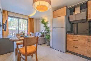 a kitchen with a table and a white refrigerator at Kalender Pansiyon Fethiye in Fethiye