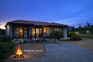 a house with a fire in front of it at Sebeshong Guest House - Moletjie in Ga-Komape