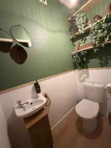 a bathroom with a white toilet and a sink at Thejungle in Freyming +3 photos
