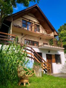 a house with a balcony and a bench in front of it at Repülőhal Apartmanház in Zebegény