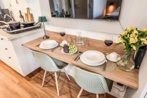 a dining room table with plates and glasses of wine at Studio SP Congonhas, CEIC-Itaú, Expo-SP in São Paulo
