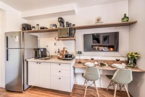 a kitchen with white cabinets and a refrigerator at Studio SP Congonhas, CEIC-Itaú, Expo-SP in São Paulo