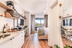 a kitchen with white cabinets and a bed in a room at Studio SP Congonhas, CEIC-Itaú, Expo-SP in São Paulo