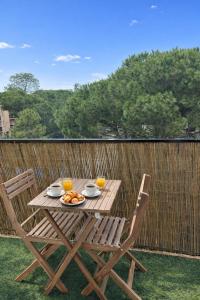 a wooden table with two chairs and two glasses of orange juice at Sakura Seaside -Expérience Japonaise en bord de mer in Argelès-sur-Mer
