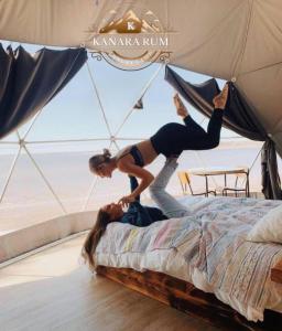 a woman is on top of a bed at RUM KANARA BUBBLE lUXURY CAMP in Wadi Rum