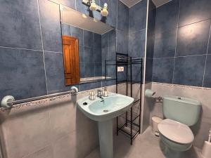 a bathroom with a sink and a toilet and a mirror at Casa Caiceda in Poo de Cabrales +21 photos