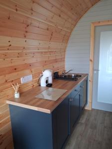 a kitchen with wooden walls and a counter top at Hilltop Glamping in Ardara