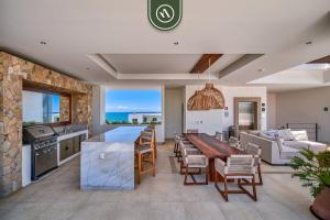 a kitchen and living room with a table and a couch at 2BR Condo with Rooftop Pool - 2 Min Walk to Beach in Bucerías