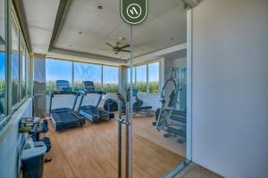 a gym with cardio equipment and a large glass wall at 2BR Condo with Rooftop Pool - 2 Min Walk to Beach in Bucerías