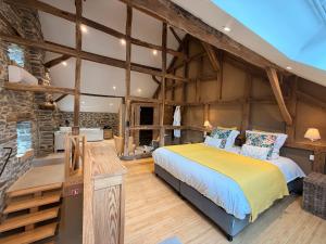 a bedroom with a bed and a stone wall at Paddock Lodge - Suites Wellness & Chambres d'hôtes in Stoumont +102 photos