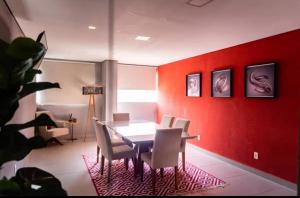 a dining room with red walls and a table and chairs at Flat Red Encanto in Sorocaba