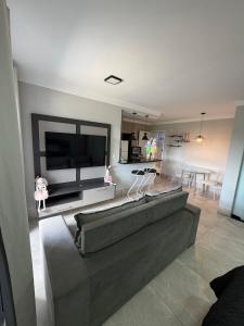 a living room with a couch and a flat screen tv at Flat Red Encanto in Sorocaba