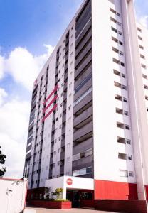 a large white building with an american flag on it at Flat Red Encanto in Sorocaba