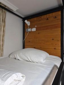a bedroom with a bed with a wooden headboard at Urban House in Batumi +8 photos
