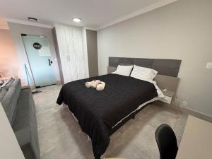 a bedroom with a bed with two stuffed animals on it at Flat Red Encanto in Sorocaba +24 photos
