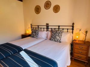 a bedroom with two beds and two lamps on the wall at Casa Caiceda in Poo de Cabrales