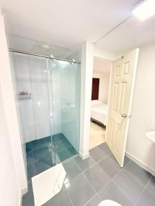 a bathroom with a glass shower and a bedroom at Mosaico Cartagena Hotel in Cartagena de Indias