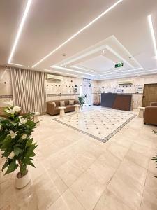 a large lobby with a large room with couches and a table at فندق رواف الفيصلية in An Naqāʼ