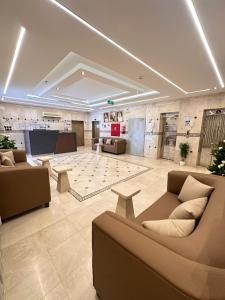 a large room with couches and tables in a building at فندق رواف الفيصلية in An Naqāʼ