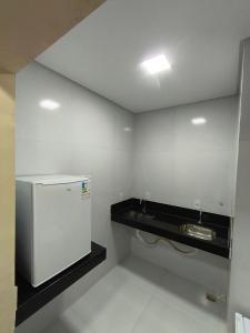 a bathroom with a sink and a refrigerator at Hotel Colibri Viçosa - Próximo a UFV in Viçosa