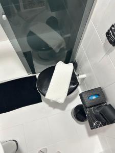 a bathroom with a black and white toilet and a mirror at Riso Suítes - Jantar Romântico in Santo Antônio do Pinhal +34 photos
