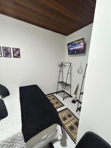 a bedroom with a bed and a tv on the wall at Riso Suítes - Jantar Romântico in Santo Antônio do Pinhal