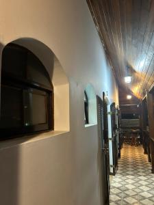 a hallway with a flat screen tv on a wall at Riso Suítes - Jantar Romântico in Santo Antônio do Pinhal
