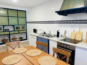 a kitchen with a wooden table with chairs and a stove at Casa Caiceda in Poo de Cabrales
