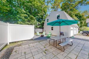 a patio with a table and an umbrella at Shop, Dine, Unwind! Family Home in Dtwn Bar Harbor in Bar Harbor