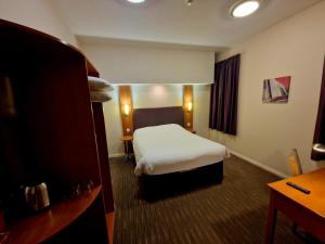 a hotel room with a bed and a desk at Charter Hotel Bournemouth in Bournemouth