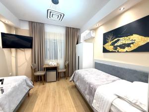 a hotel room with two beds and a table at Prime Location - shared Bath in Tirana