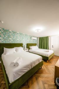 a bedroom with two beds and a floral wall at Chalet 239-Boutique Hotel in West Dover