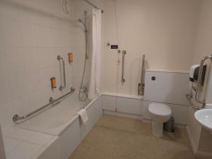 a bathroom with a shower and a toilet and a sink at Charter Hotel Bournemouth in Bournemouth