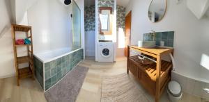 a bathroom with a tub and a washing machine at Gîte "Entre fraises et mer" in Landrethun-lès-Ardres +15 photos