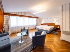 a bedroom with a bed and a living room at Hotel Hecht in Appenzell +32 photos